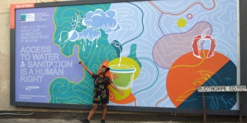 Emma Blake Morsi standing in front of her artwork.